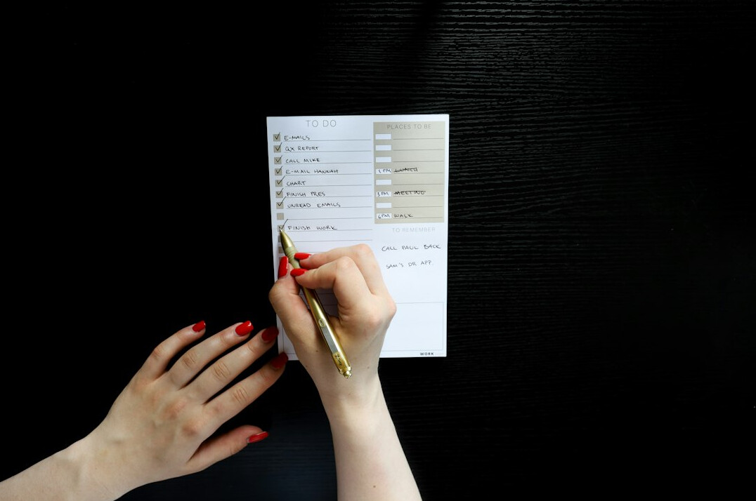 person writing budget on paper